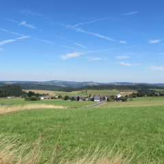 Blick über die grünen Felder auf den Ort Winnerath